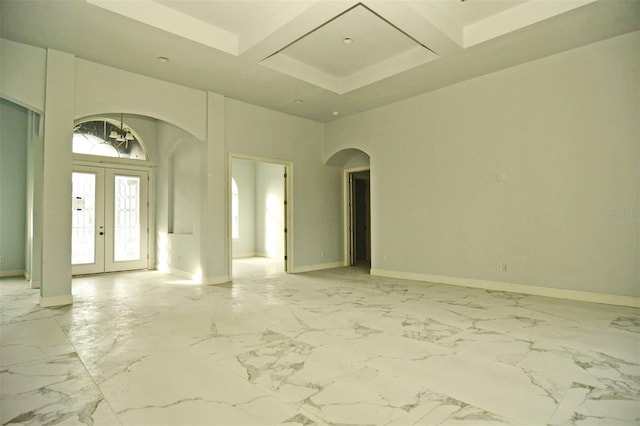 spare room featuring a high ceiling, coffered ceiling, beam ceiling, and french doors