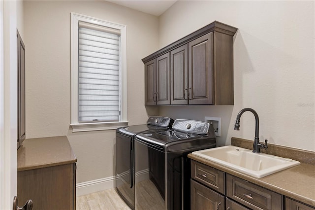 laundry area featuring washer hookup, independent washer and dryer, sink, cabinets, and light wood-type flooring