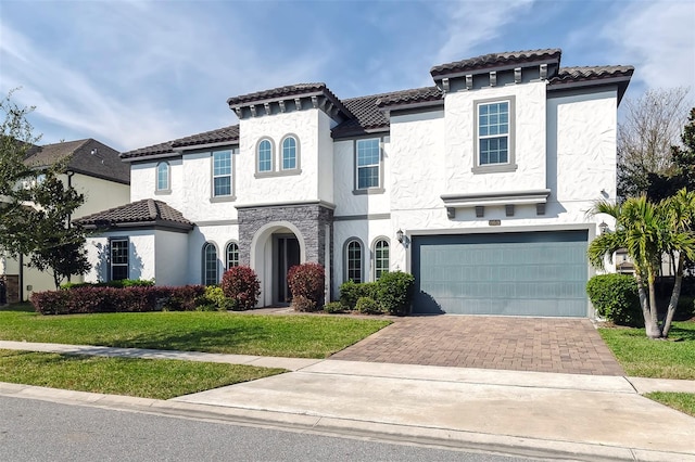 mediterranean / spanish home featuring a front lawn and a garage