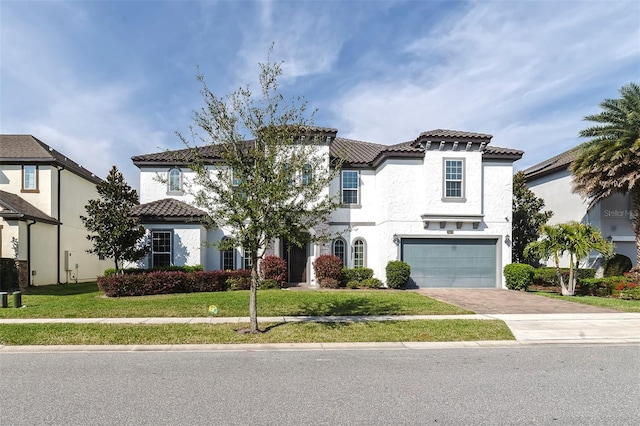 mediterranean / spanish house with a front yard and a garage