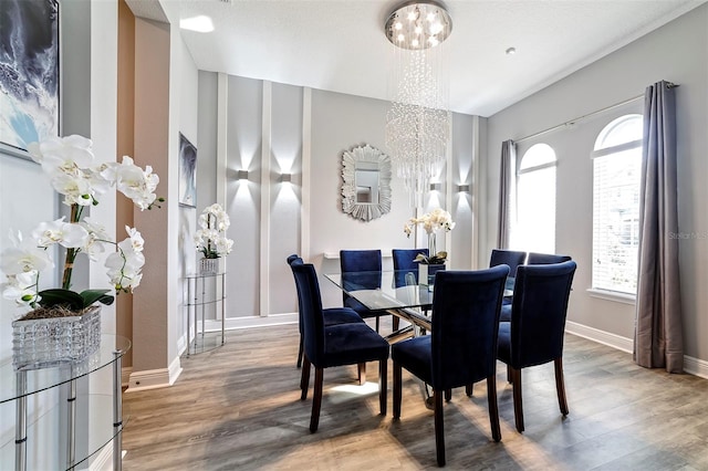 dining room featuring a chandelier, light hardwood / wood-style floors, and a textured ceiling