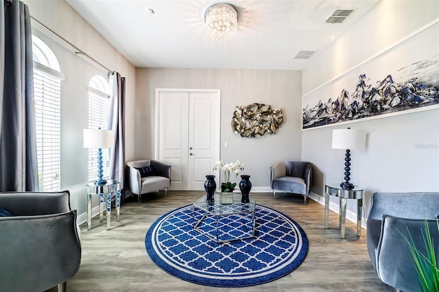 sitting room featuring a chandelier and hardwood / wood-style floors