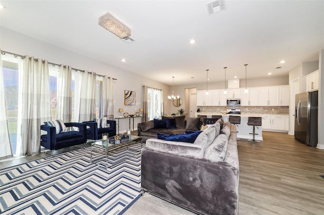 living room featuring a chandelier and light hardwood / wood-style flooring