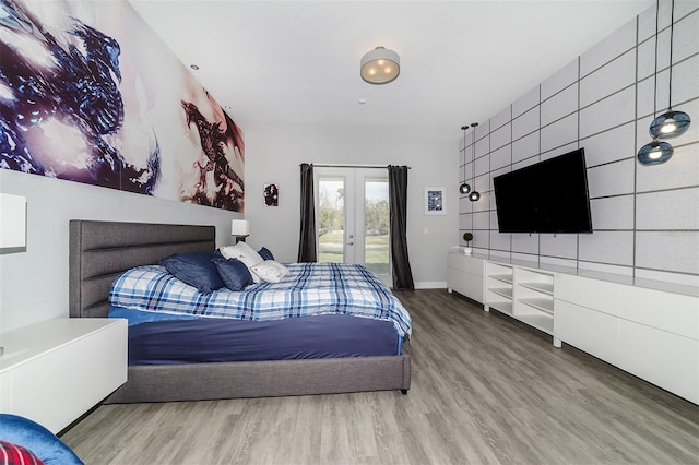 bedroom featuring french doors, access to exterior, and light hardwood / wood-style flooring