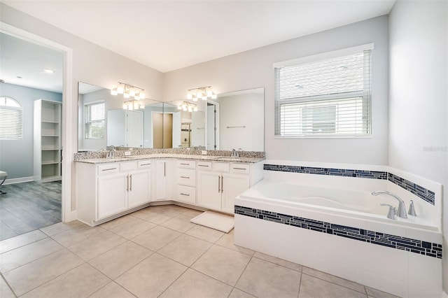 bathroom with large vanity, tile flooring, double sink, and tiled tub