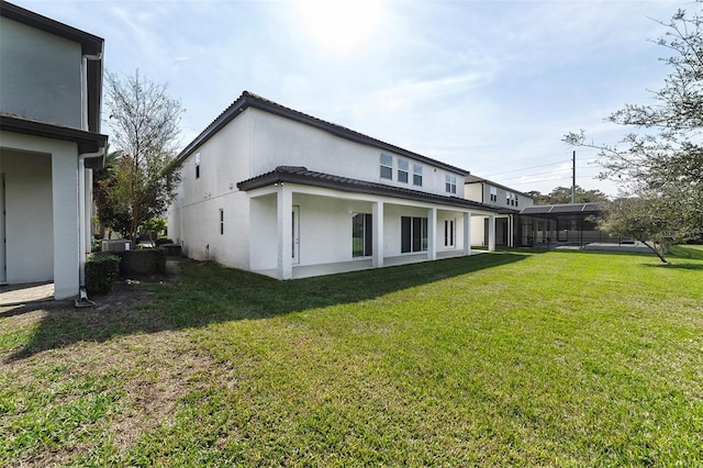 rear view of property featuring a lawn