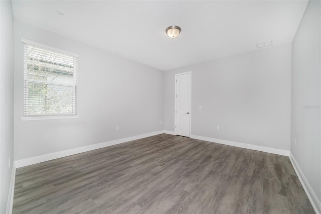 unfurnished room with dark hardwood / wood-style flooring