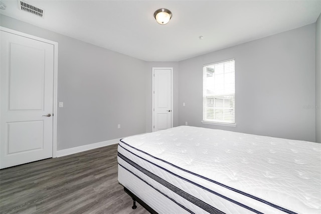 bedroom with dark hardwood / wood-style flooring