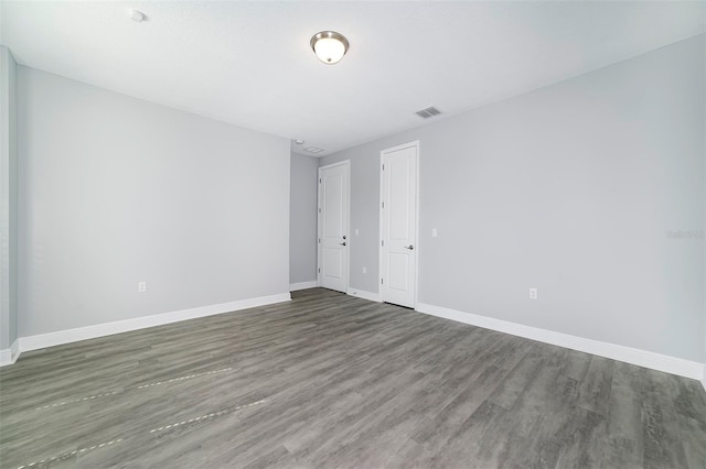 empty room with dark hardwood / wood-style flooring