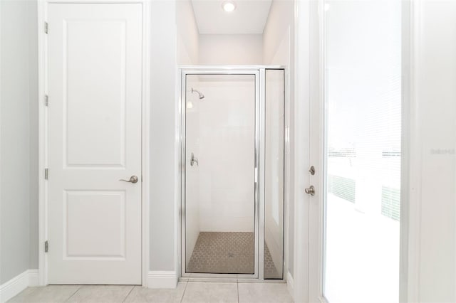 bathroom with an enclosed shower and tile floors