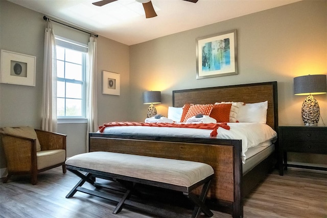 bedroom with dark hardwood / wood-style flooring and ceiling fan