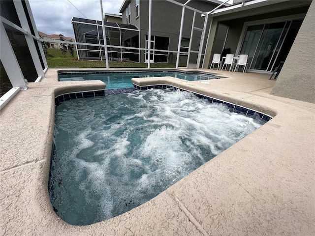 view of pool featuring glass enclosure and a patio area