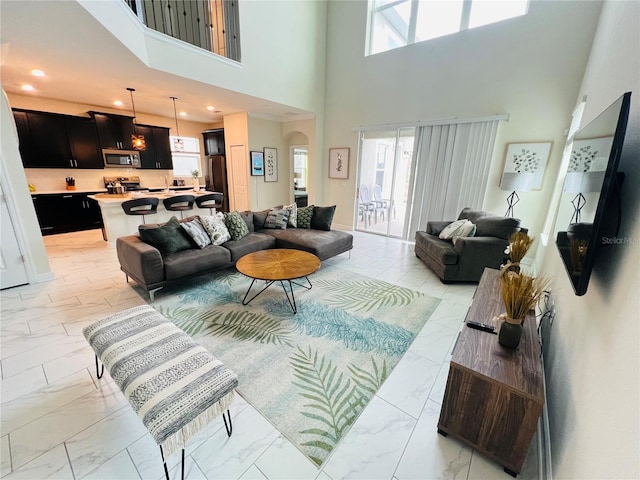 tiled living room with a high ceiling and a wealth of natural light