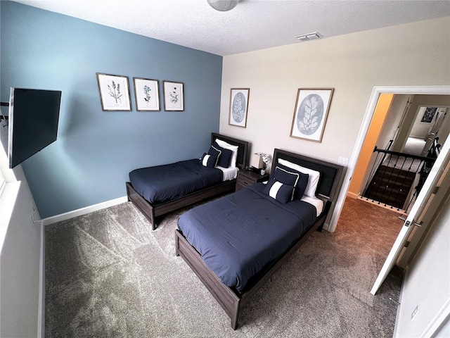 bedroom featuring dark carpet and a textured ceiling