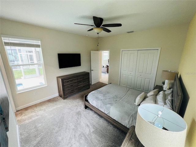 bedroom with a closet, light carpet, and ceiling fan