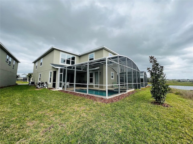 back of house with a patio, glass enclosure, and a yard