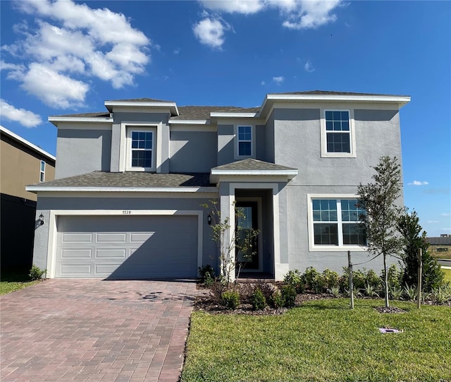 view of front of property with a garage and a front lawn