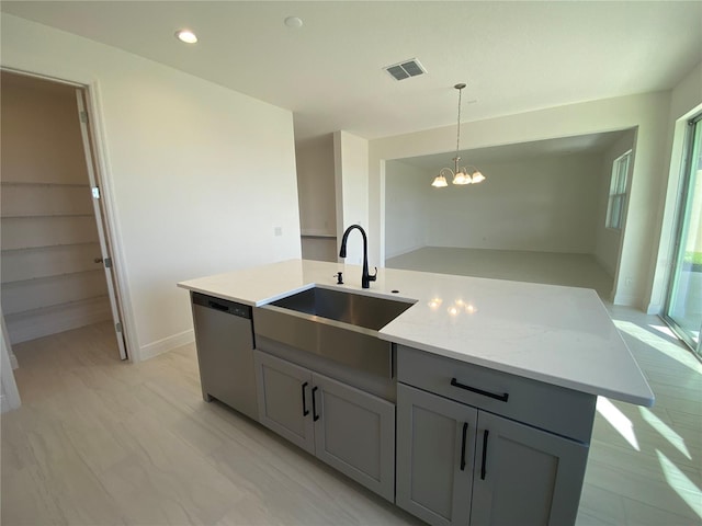 kitchen with sink, dishwasher, a kitchen island with sink, gray cabinetry, and hanging light fixtures