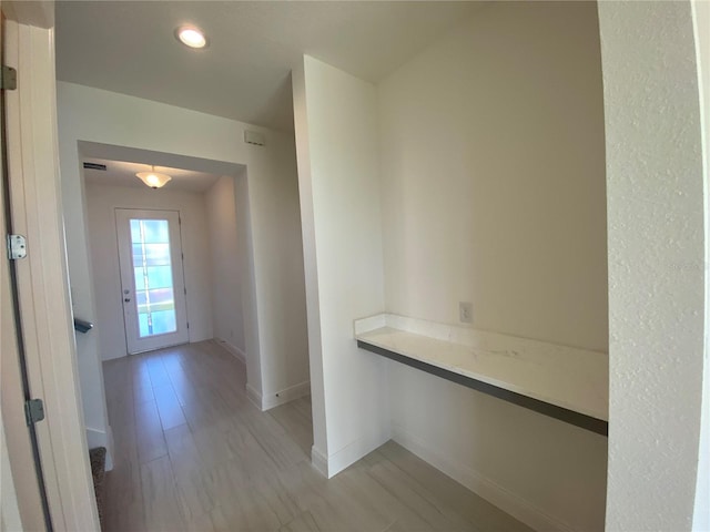 hallway with light hardwood / wood-style floors