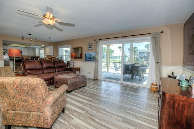 living room with light hardwood / wood-style flooring and ceiling fan