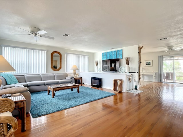 living room featuring ceiling fan and hardwood / wood-style flooring