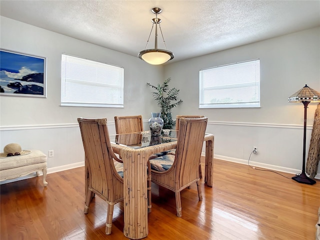 dining room featuring a textured ceiling and light hardwood / wood-style flooring