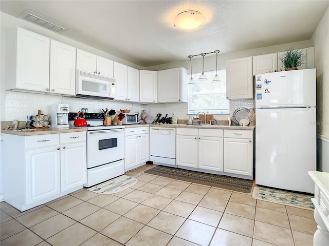 kitchen featuring white appliances, sink, hanging light fixtures, white cabinets, and light tile flooring