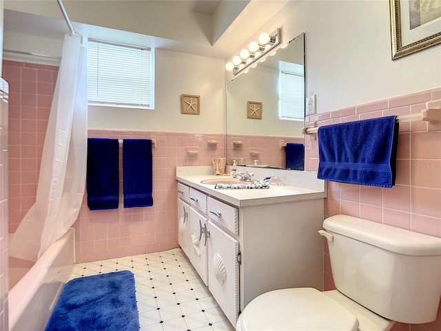 full bathroom featuring toilet, vanity with extensive cabinet space, tasteful backsplash, tile walls, and tile floors