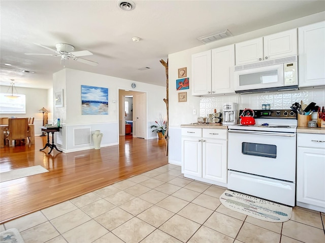 kitchen with backsplash, white appliances, ceiling fan, and white cabinets