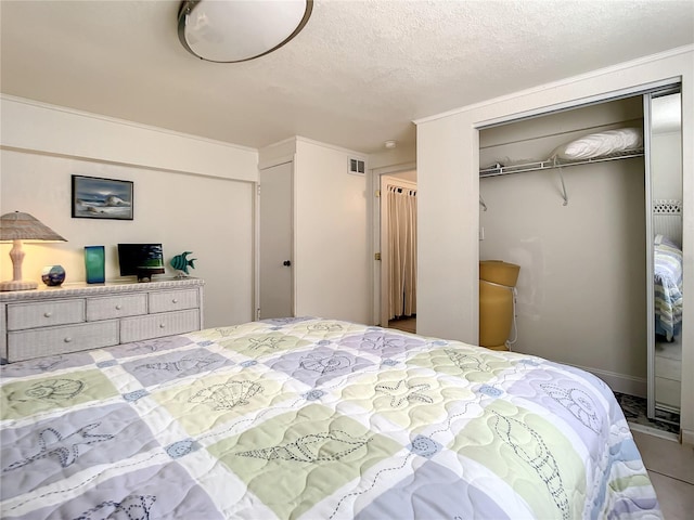 bedroom with tile floors, a closet, and a textured ceiling