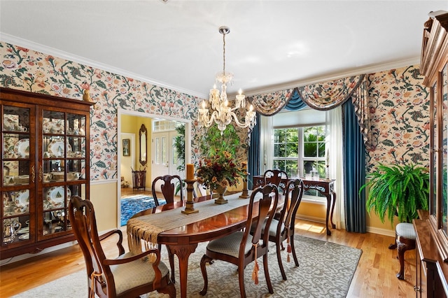 dining room featuring crown molding, light hardwood / wood-style floors, and an inviting chandelier