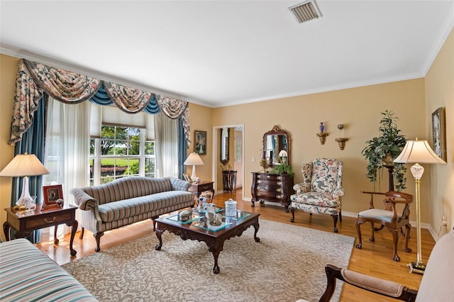 living room with crown molding and light wood-type flooring