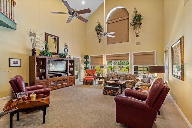 living room featuring a high ceiling, light carpet, and ceiling fan