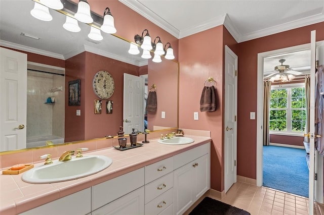 bathroom with double sink, ceiling fan, tile flooring, vanity with extensive cabinet space, and ornamental molding