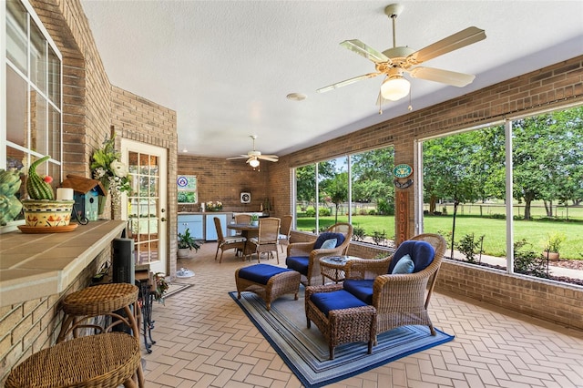 sunroom / solarium featuring ceiling fan