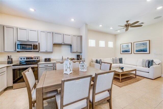 kitchen featuring gray cabinets, stainless steel appliances, ceiling fan, and light tile floors