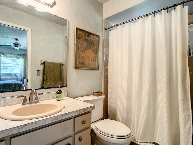 bathroom with vanity with extensive cabinet space, ceiling fan, and toilet