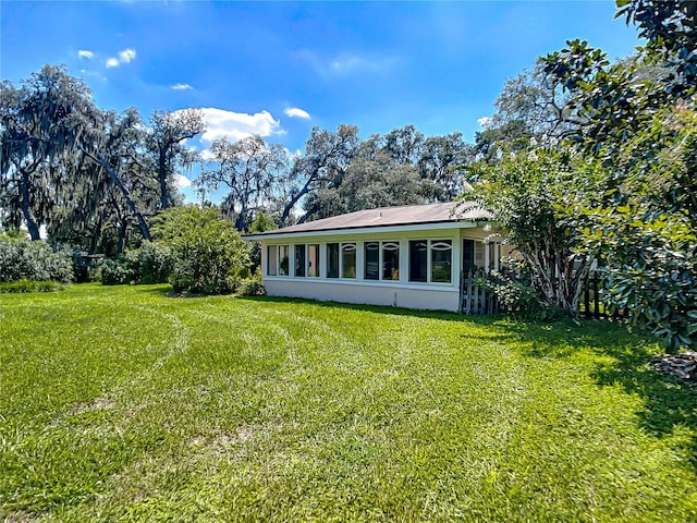 rear view of property featuring a lawn