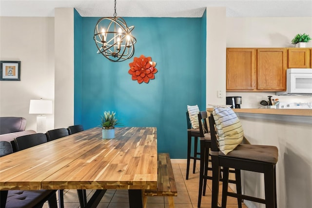 dining room featuring a notable chandelier and light tile floors