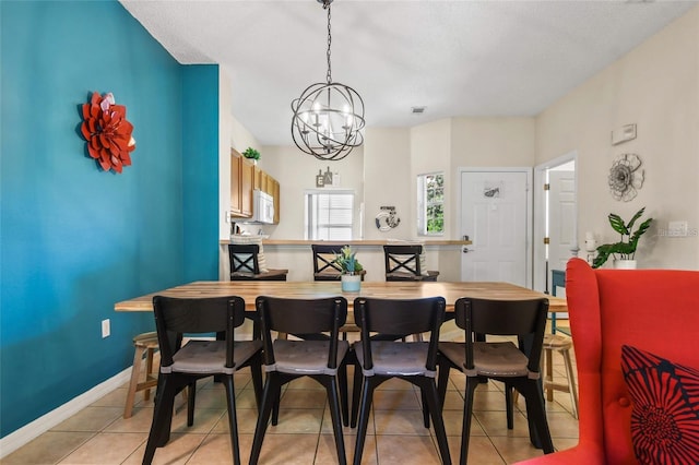 dining area with an inviting chandelier and light tile floors