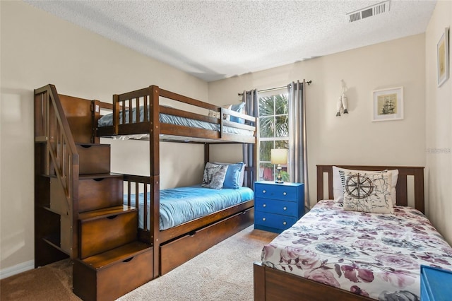 bedroom with light carpet and a textured ceiling