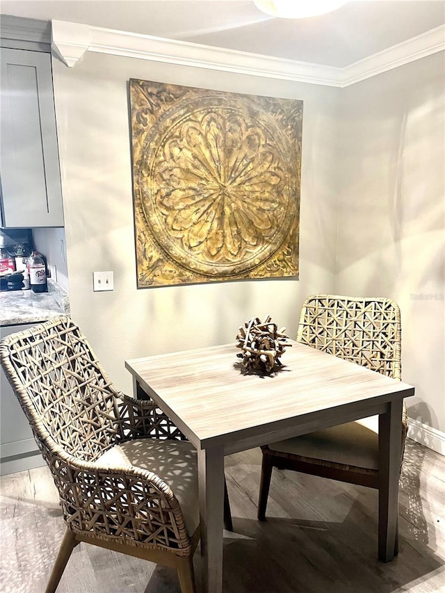 dining room with crown molding and hardwood / wood-style flooring