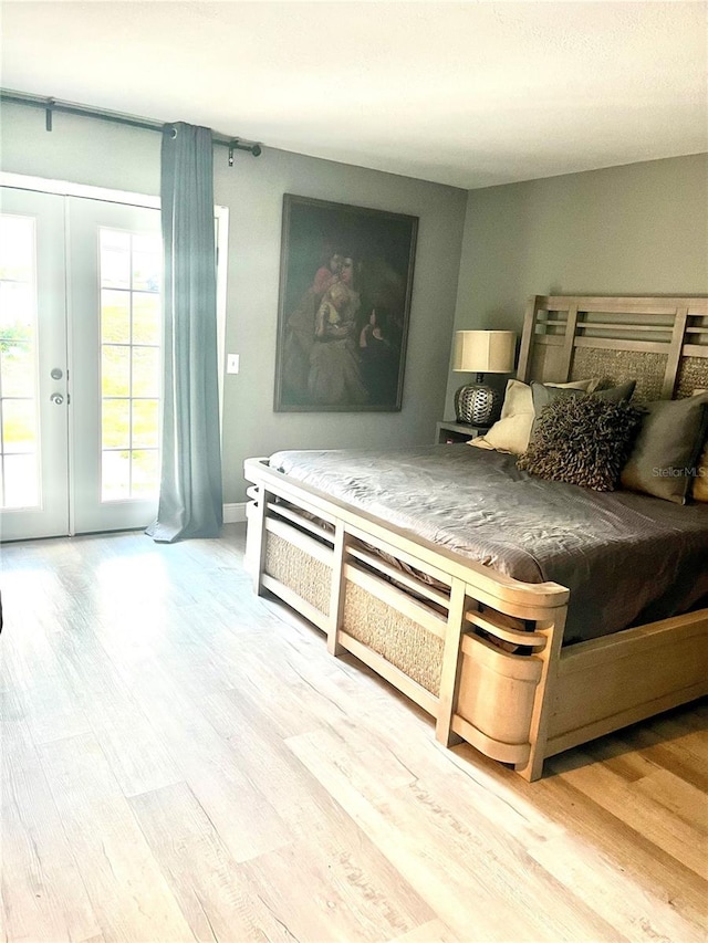 bedroom with access to outside, french doors, and light hardwood / wood-style flooring