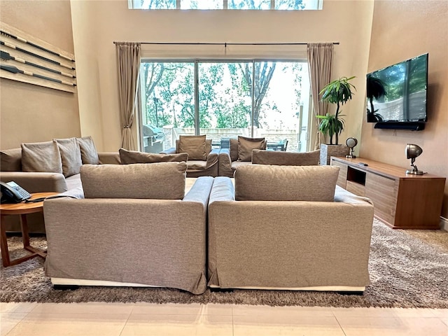 tiled living room with a healthy amount of sunlight and a towering ceiling