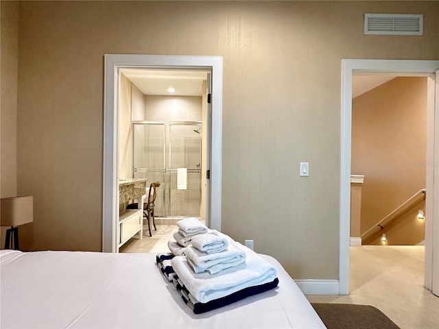 bedroom with light colored carpet and connected bathroom