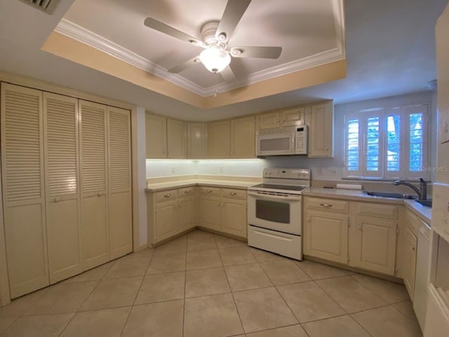 kitchen featuring ceiling fan, light tile patterned floors, a raised ceiling, sink, and white appliances