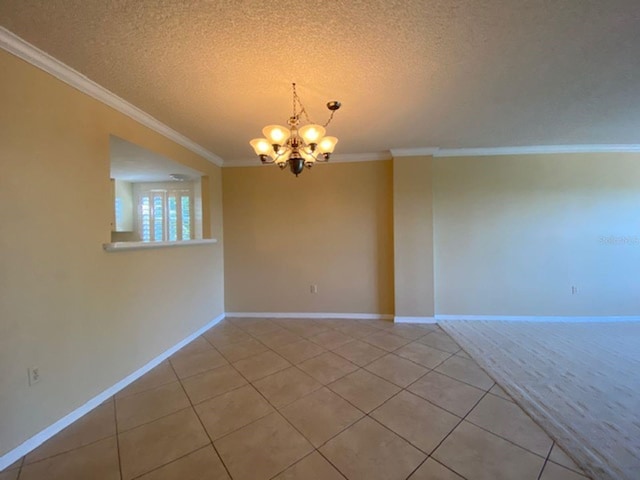 spare room featuring an inviting chandelier, crown molding, a textured ceiling, and light tile patterned floors