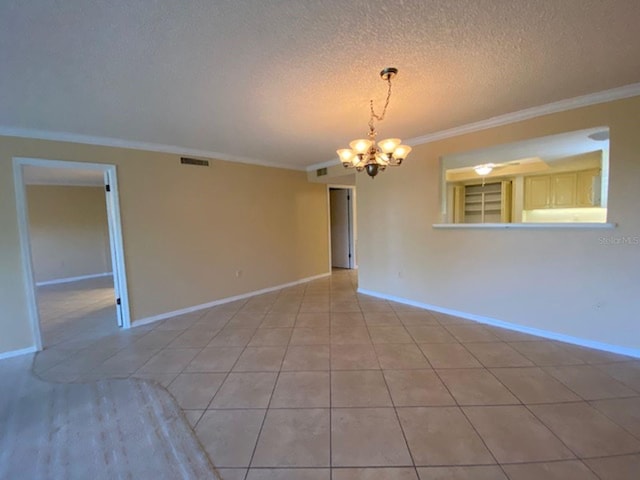 spare room with a notable chandelier, ornamental molding, a textured ceiling, and light tile patterned floors