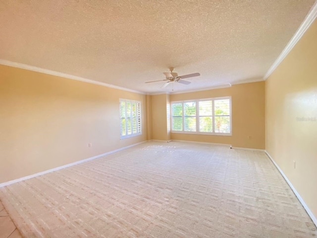 carpeted empty room featuring crown molding, a textured ceiling, and ceiling fan