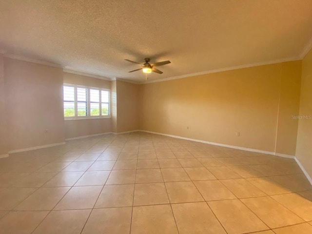 spare room featuring ceiling fan, crown molding, and light tile patterned floors